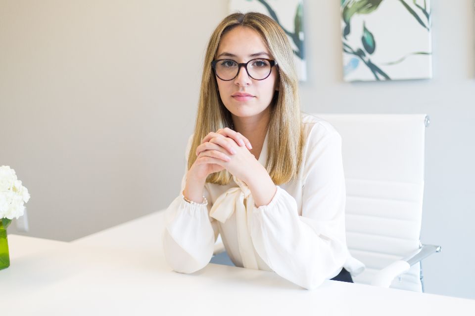 Professional woman seated at a desk, listening